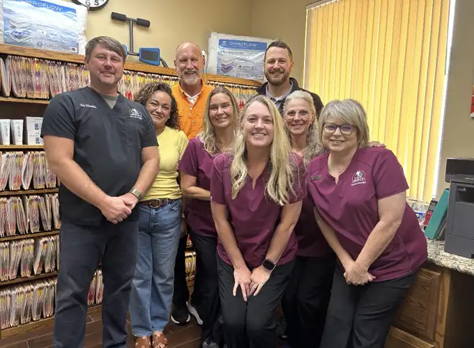 Chiropractor Jackson TN Team photo inside a chiropractic office, featuring eight staff members standing together